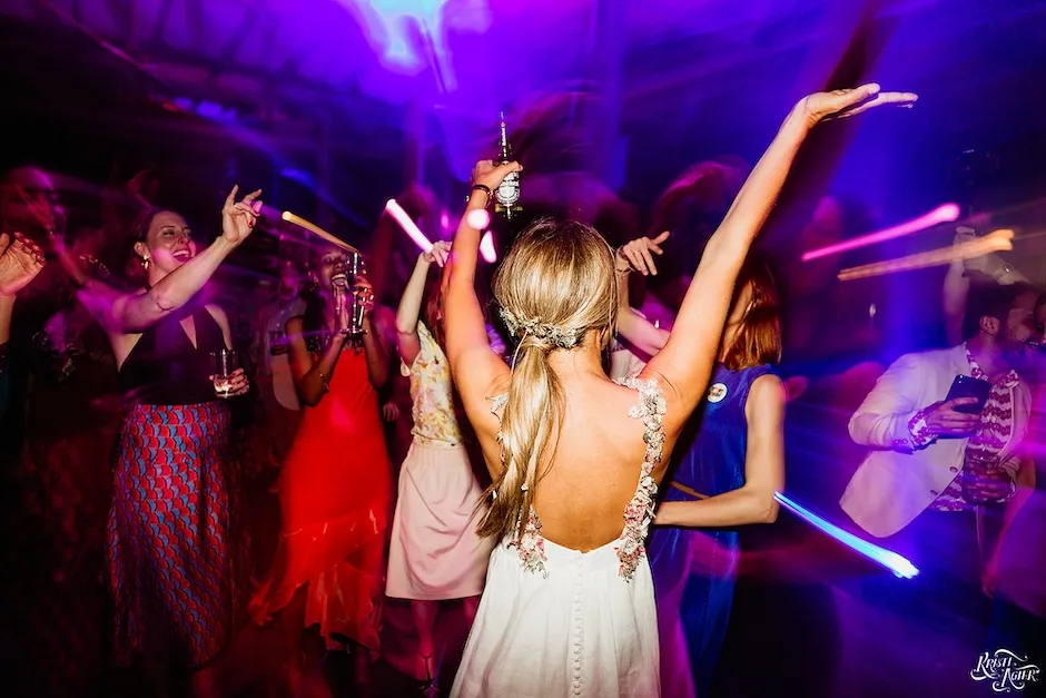 A bride waving her arms while dancing to the best DJ in cape town