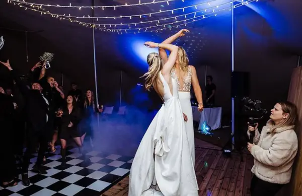 Bride dancing on a black and white chequered dance floor in blue light and low fog